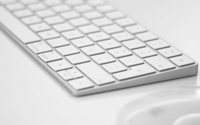 a computer keyboard and a mouse on a table.