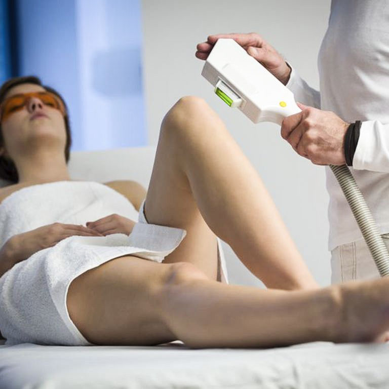 a woman getting laser hair removal from a man.