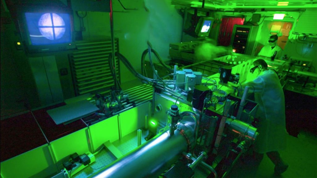 a man in a lab coat working on a machine.