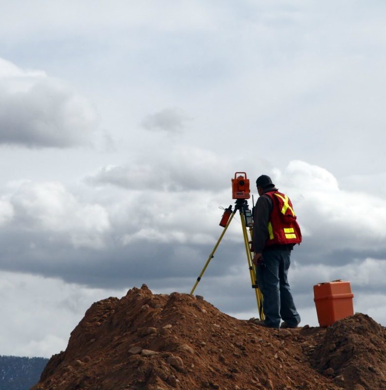 a man standing on top of a pile of dirt.