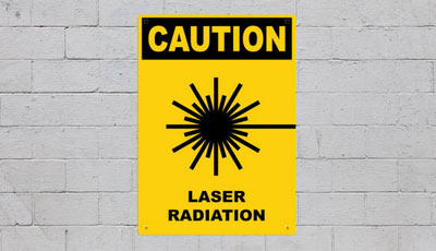 a caution sign on white wall with laser cut design