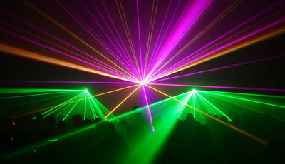 a group of people standing in front of a laser light.