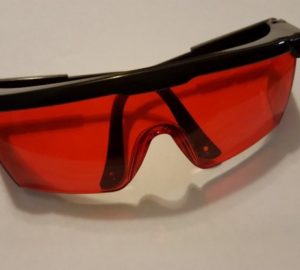 a pair of red glasses sitting on top of a white table.