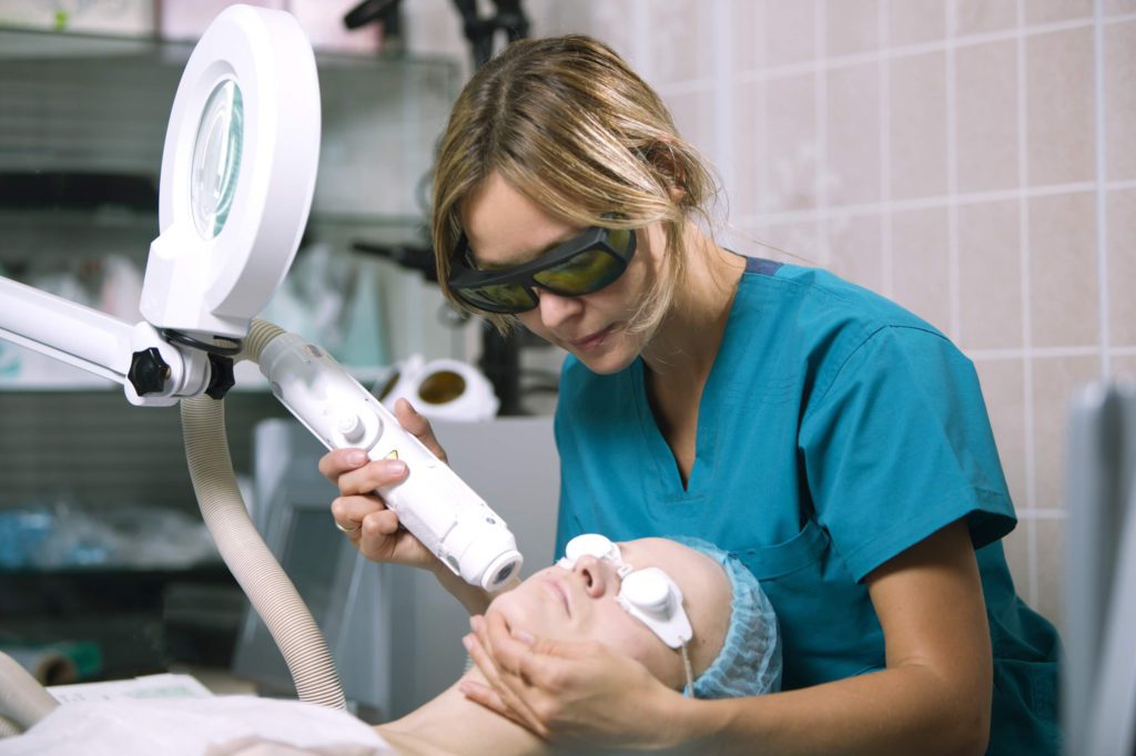 A woman undergoing a cosmetic laser treatment on her face at the hospital.