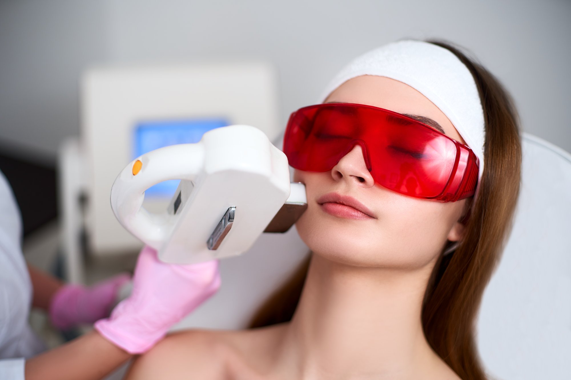 a woman with red glasses holding a white object.