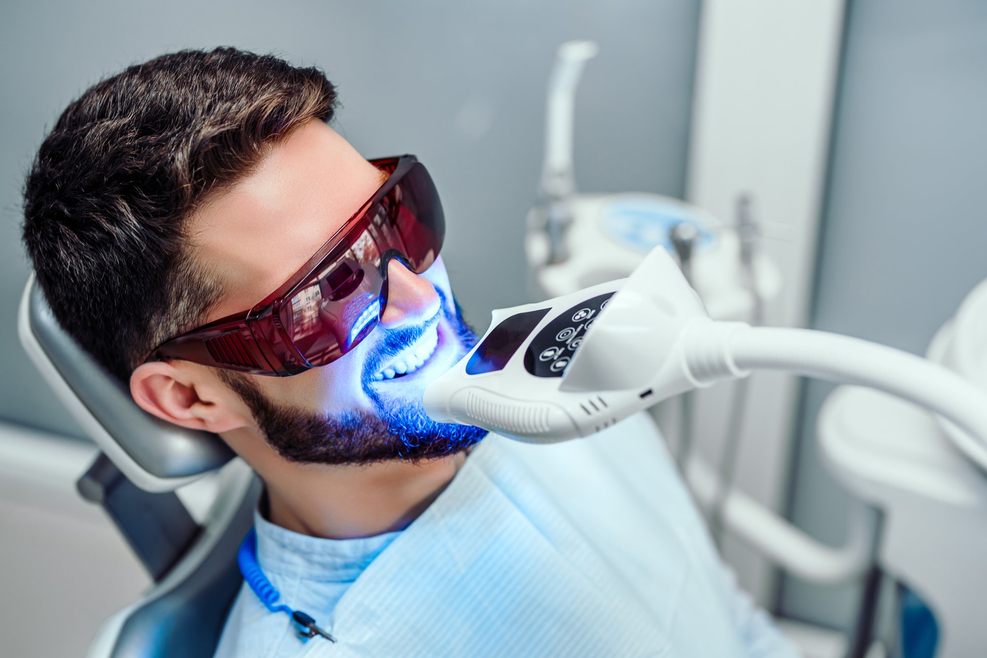 a man getting his teeth brushed by a dentist.