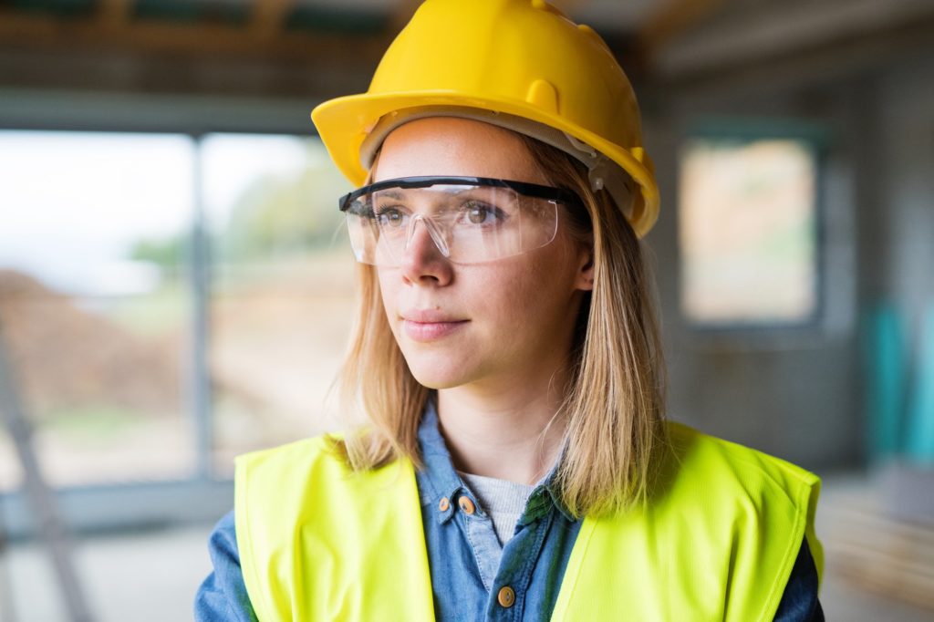 a woman wearing a hard hat and safety glasses.