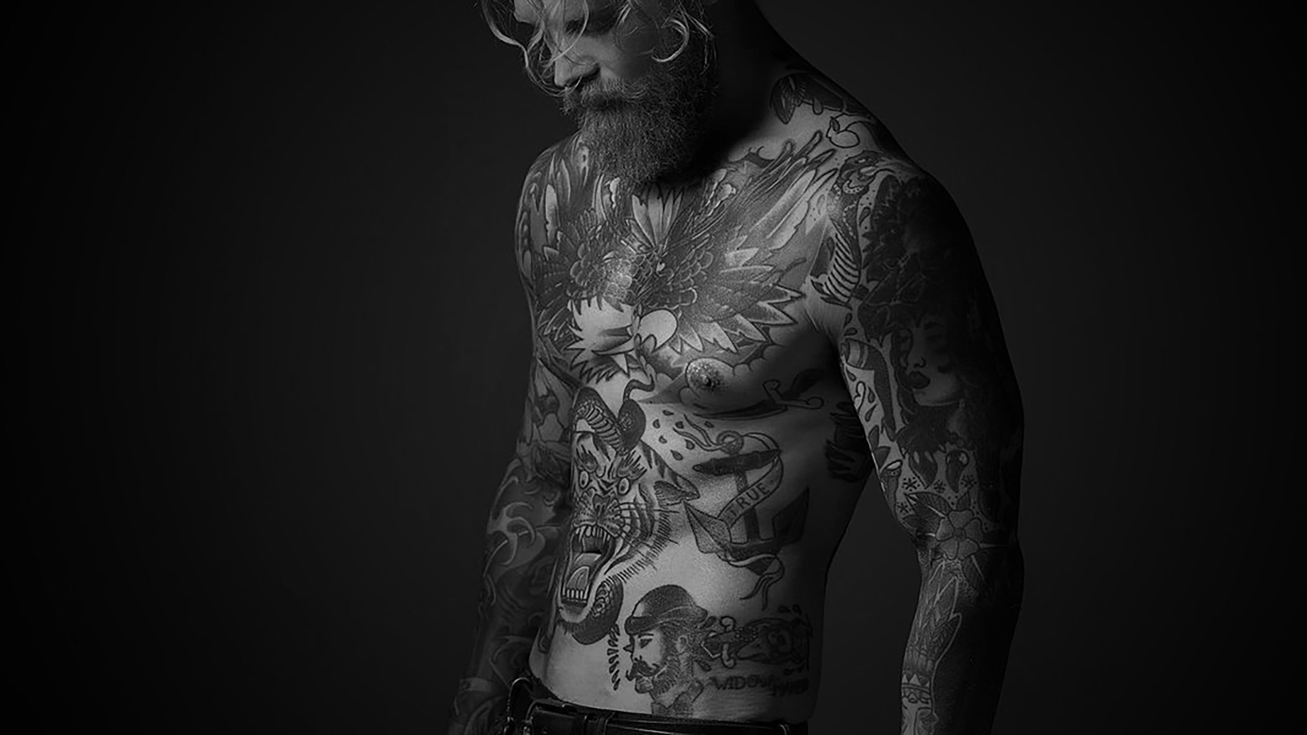 A man with tattoos on his body considering laser tattoo removal.