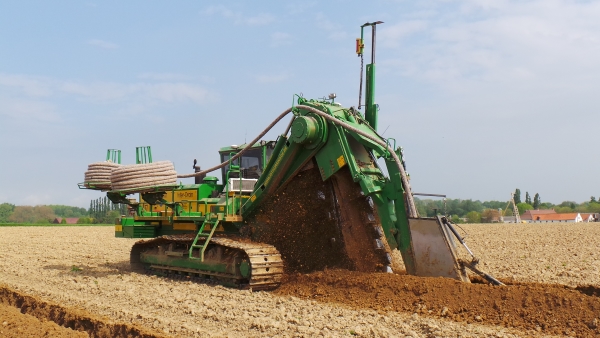 A tractor is using farm tile drainage in a plowed field.