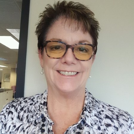 a woman with glasses is smiling for the camera.