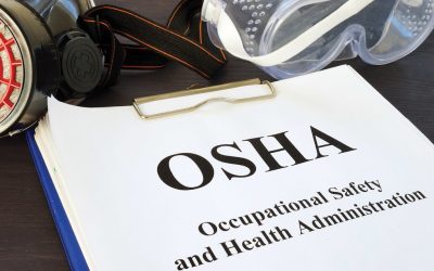 Manual on occupational safety and health administration (osha) with safety equipment including goggles and a respirator.